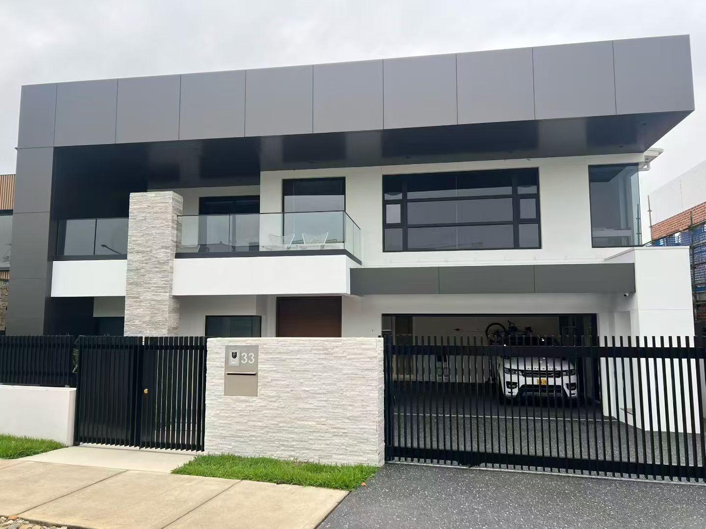 Completed street frontage with render, stone feature panel and black aluminium windows